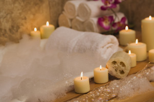 Apartments in San Antonio near Six Flags Fiesta A luxurious bath tub adorned with candles, soap, and flowers.